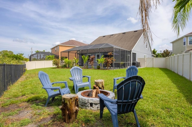 view of yard featuring a lanai and an outdoor fire pit