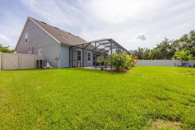 rear view of house featuring a lawn, a lanai, and a patio area