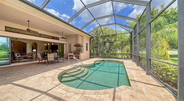 view of swimming pool featuring a patio, ceiling fan, and glass enclosure