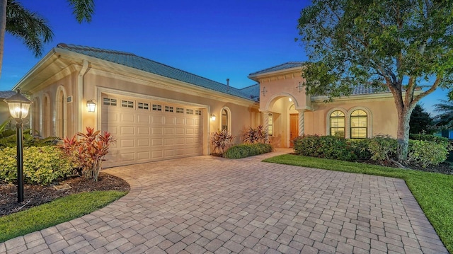 mediterranean / spanish home featuring a garage