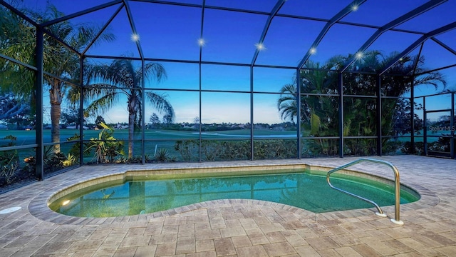 pool at dusk with a lanai and a patio area