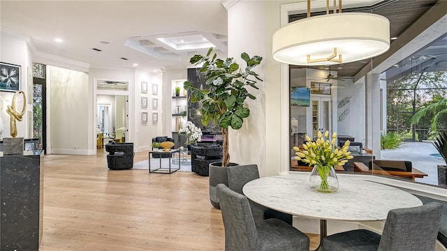 dining space with light wood-type flooring and crown molding