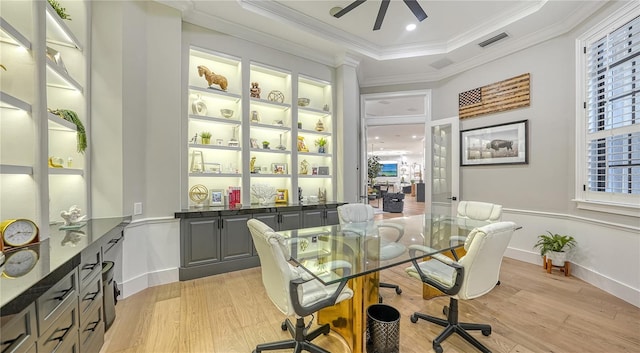 home office with light hardwood / wood-style flooring, ceiling fan, a raised ceiling, and crown molding