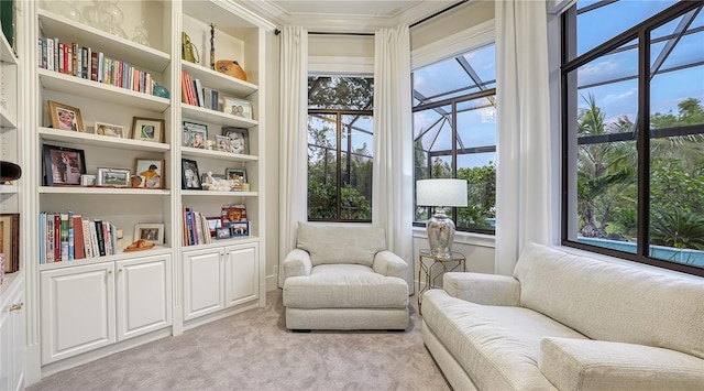 living area featuring crown molding, built in shelves, and light carpet