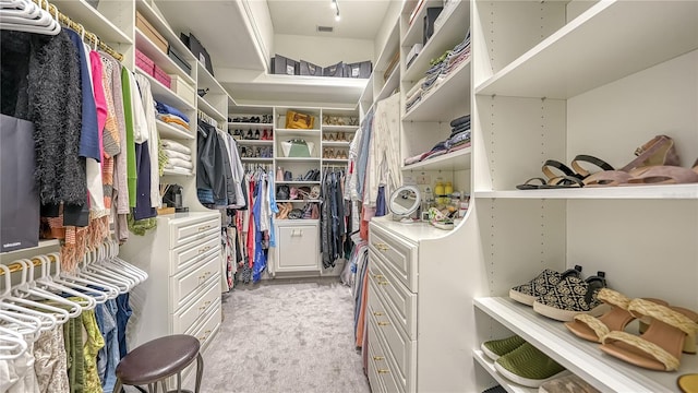 walk in closet featuring light carpet