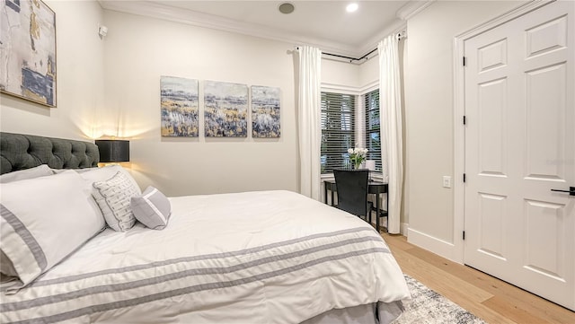 bedroom with light wood-type flooring and crown molding