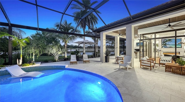 view of pool featuring glass enclosure, ceiling fan, and a patio