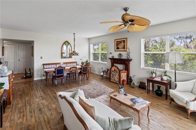 living room with ceiling fan, hardwood / wood-style flooring, a healthy amount of sunlight, and a textured ceiling