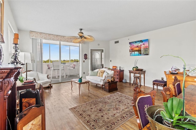 living room with ceiling fan and light hardwood / wood-style flooring