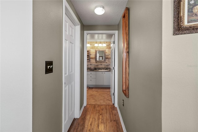 hall featuring a textured ceiling and hardwood / wood-style floors