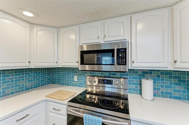 kitchen featuring a textured ceiling, backsplash, stainless steel appliances, and white cabinets