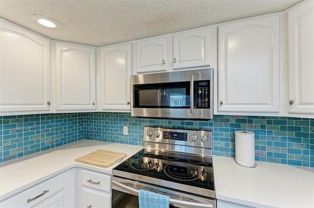 kitchen featuring light countertops, a textured ceiling, stainless steel appliances, white cabinetry, and tasteful backsplash