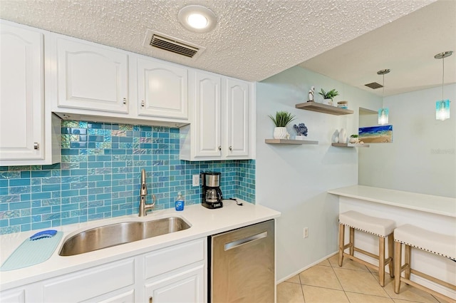 kitchen featuring white cabinets, stainless steel dishwasher, hanging light fixtures, and sink