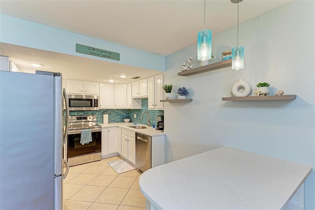 kitchen with backsplash, open shelves, a sink, stainless steel appliances, and white cabinetry
