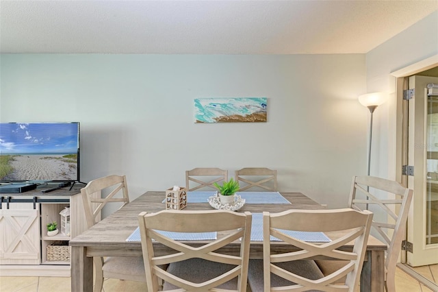 tiled dining room featuring a textured ceiling