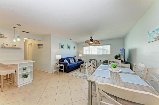 dining area featuring light tile patterned floors, ceiling fan, a textured ceiling, and visible vents