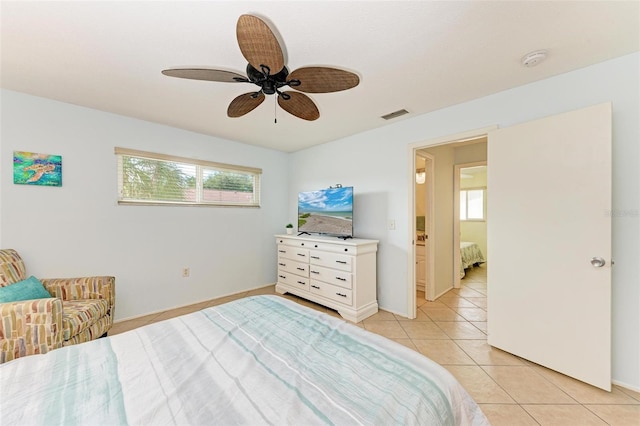 bedroom featuring ceiling fan, multiple windows, and light tile patterned floors