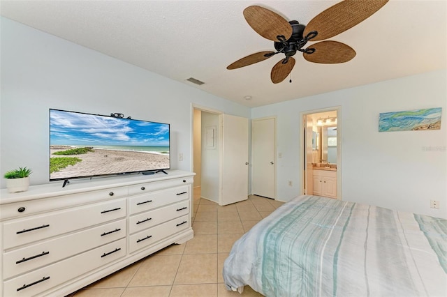 bedroom with light tile patterned floors, ceiling fan, ensuite bath, and visible vents