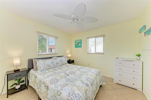 tiled bedroom with ceiling fan and multiple windows