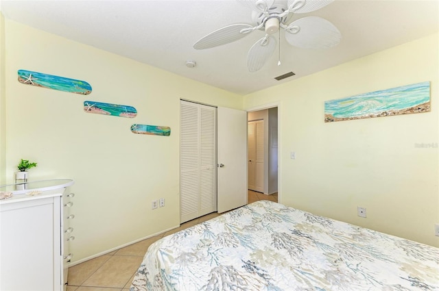 bedroom featuring ceiling fan, light tile patterned flooring, and a closet