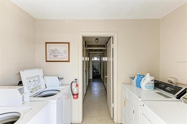 common laundry area featuring a textured ceiling and washing machine and dryer