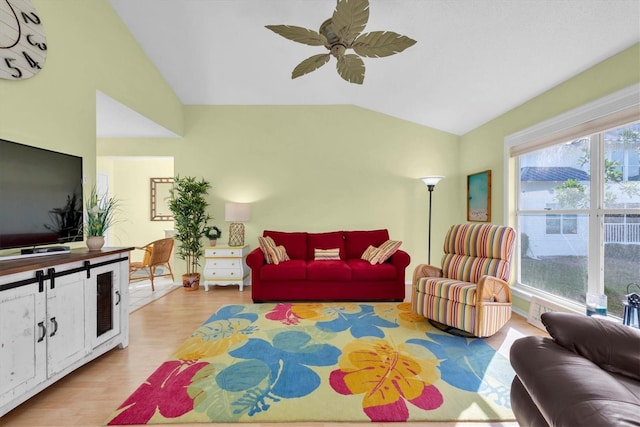 living room with vaulted ceiling, ceiling fan, and light wood-type flooring