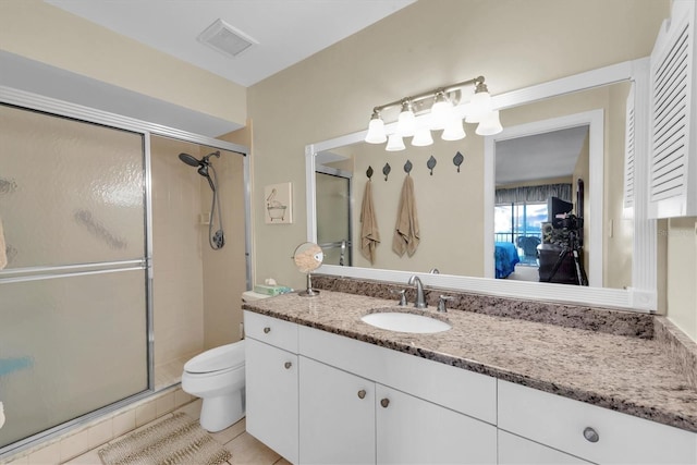 bathroom with tile patterned floors, vanity, toilet, and an enclosed shower