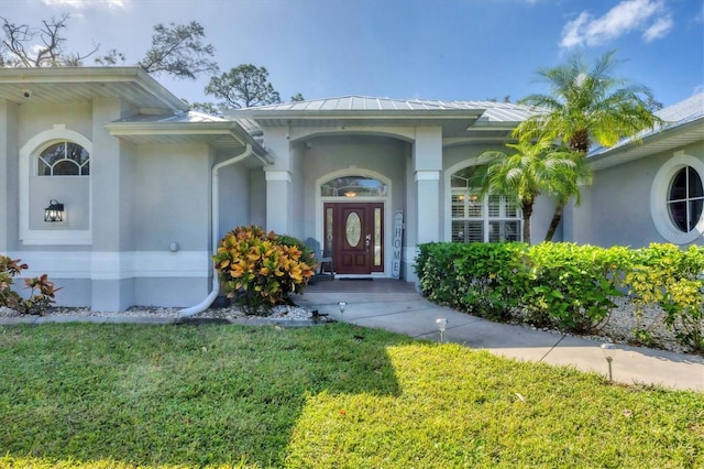 entrance to property with a lawn