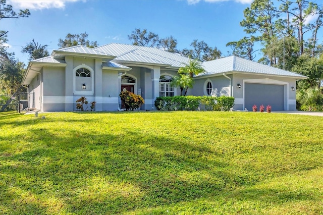 single story home with a garage, a front yard, metal roof, and stucco siding