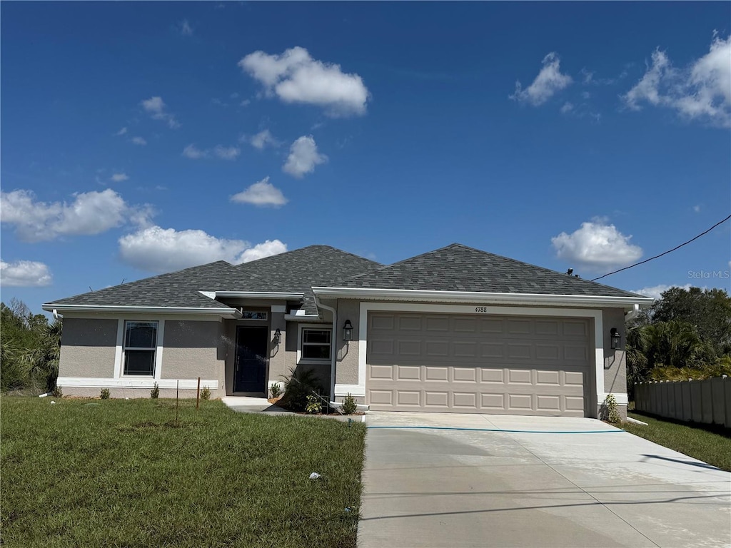 view of front of property featuring a garage, a shingled roof, driveway, stucco siding, and a front lawn