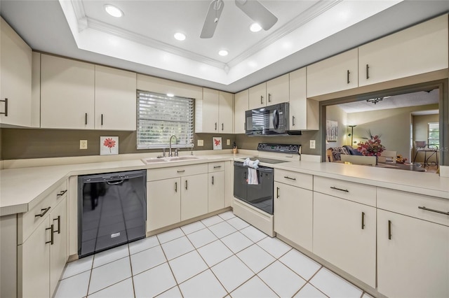 kitchen with cream cabinetry, black appliances, sink, and a raised ceiling