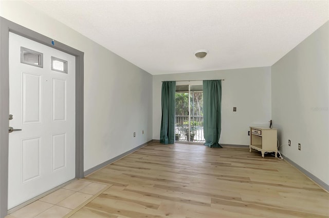 empty room featuring a textured ceiling and light hardwood / wood-style floors