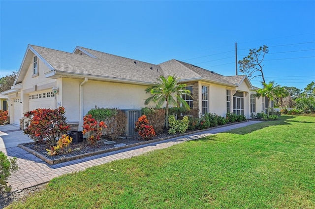 view of side of property featuring a garage and a lawn