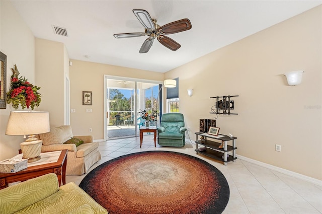 living area with ceiling fan and light tile patterned floors