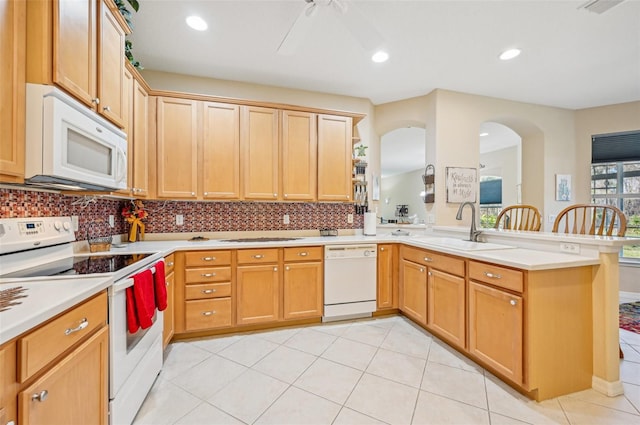 kitchen with white appliances, decorative backsplash, sink, kitchen peninsula, and ceiling fan