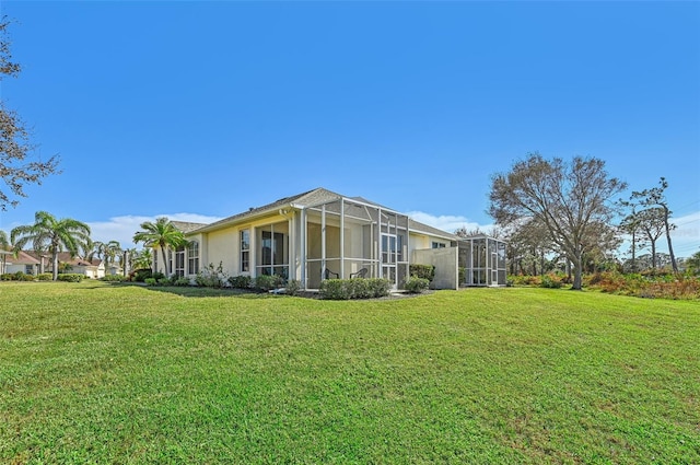 back of house with a lanai and a yard