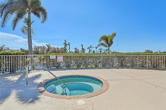 view of swimming pool with a hot tub