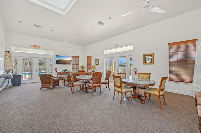 carpeted dining room with ceiling fan, plenty of natural light, and french doors