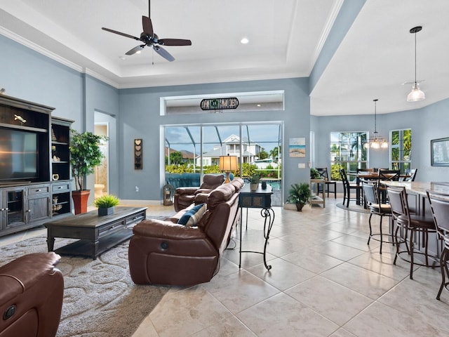 tiled living room featuring a towering ceiling, ceiling fan, a raised ceiling, and ornamental molding