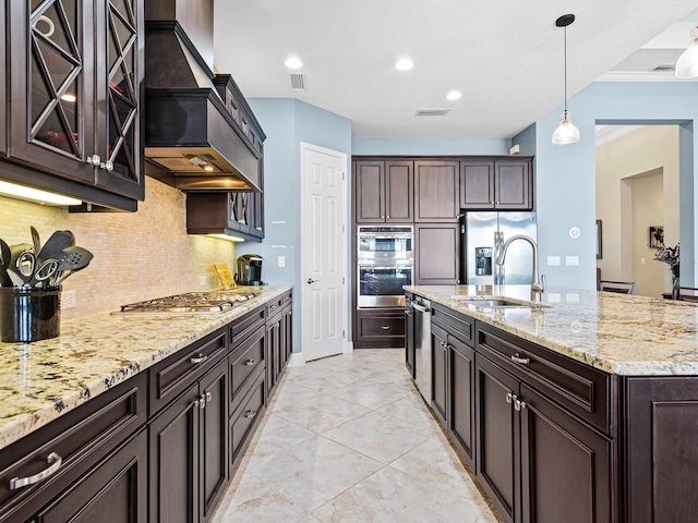 kitchen featuring decorative light fixtures, appliances with stainless steel finishes, sink, and dark brown cabinetry