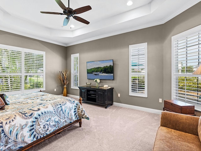 bedroom featuring ceiling fan, multiple windows, and a raised ceiling