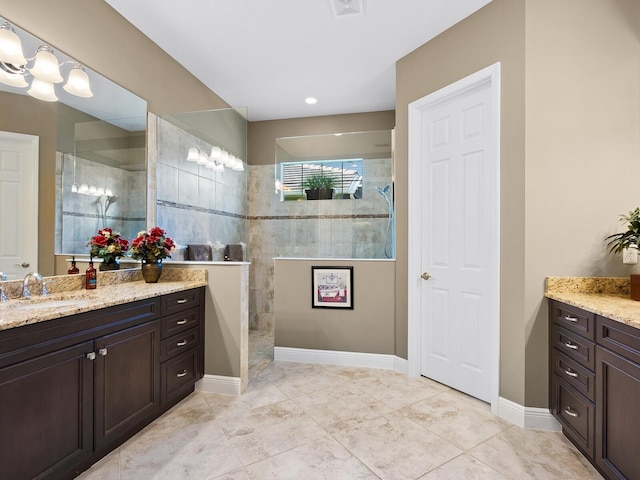 bathroom featuring vanity, tile patterned floors, and tiled shower