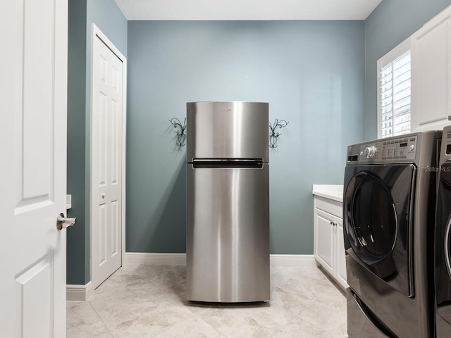 washroom featuring cabinets and washing machine and clothes dryer