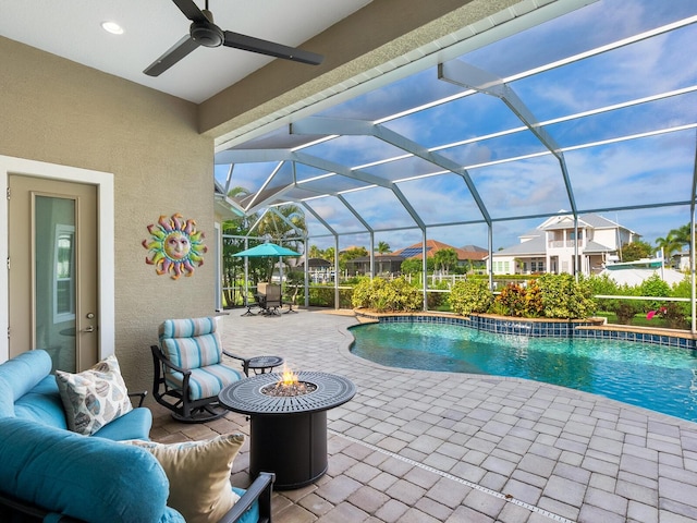 view of pool featuring ceiling fan, glass enclosure, and a patio area