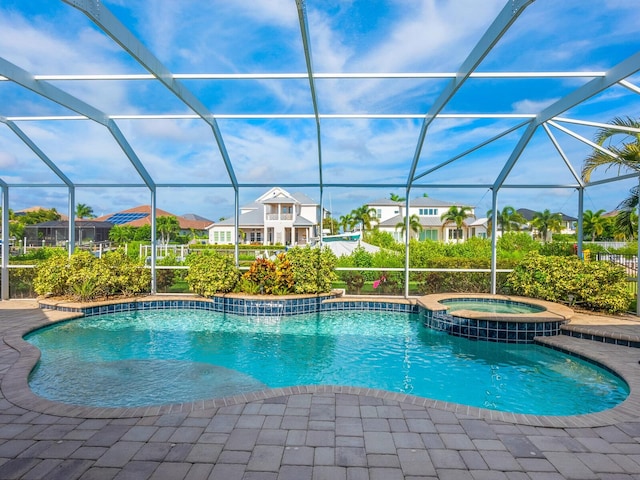 view of pool with a lanai and an in ground hot tub