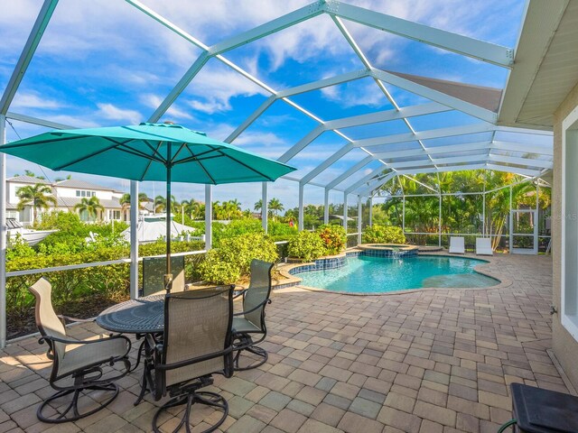 view of swimming pool featuring glass enclosure and a patio area