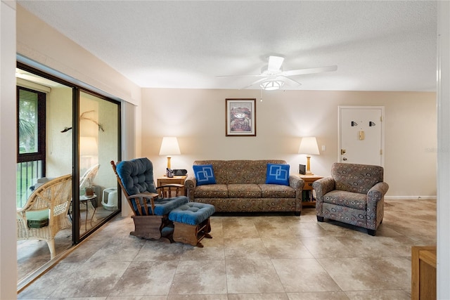 living room with ceiling fan and a textured ceiling