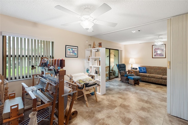 interior space with a textured ceiling and ceiling fan