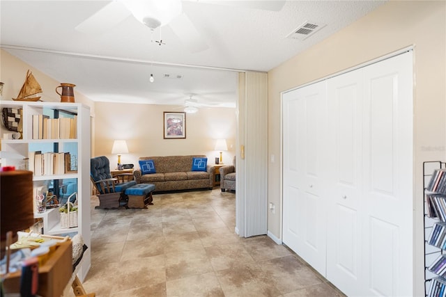 living room featuring a textured ceiling and ceiling fan