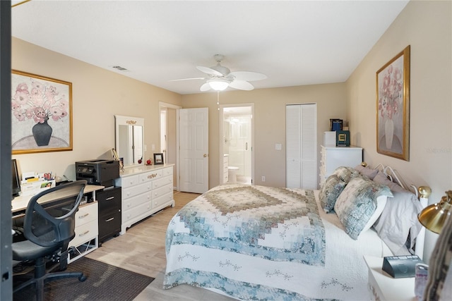 bedroom with ensuite bath, a closet, light hardwood / wood-style flooring, and ceiling fan